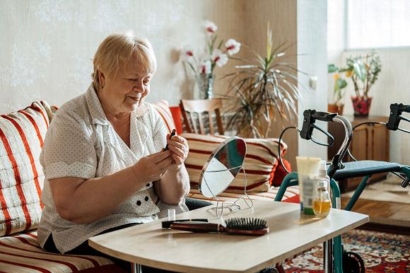 elderly lady applying lipstick