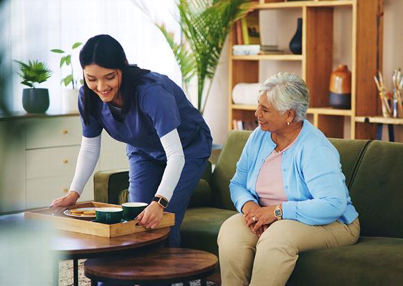 carer bringing lady tea and biscuits 
