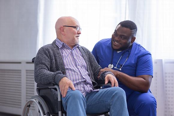 carer with elderly man in wheel chair 