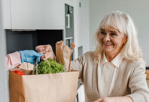 Elderly lady collecting shopping from the front door