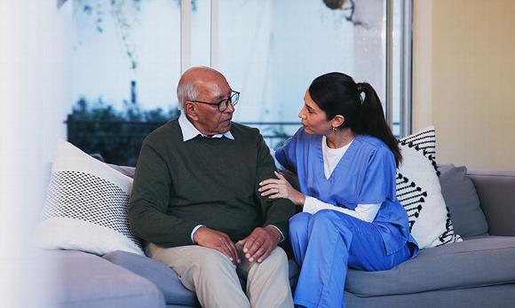 female care worker sitting on couch with man